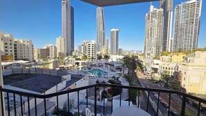 A high-rise building with a pool, surrounded by other tall buildings.