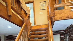 Eine Holztreppe mit Handlauf, die zu einer oberen Etage führt.