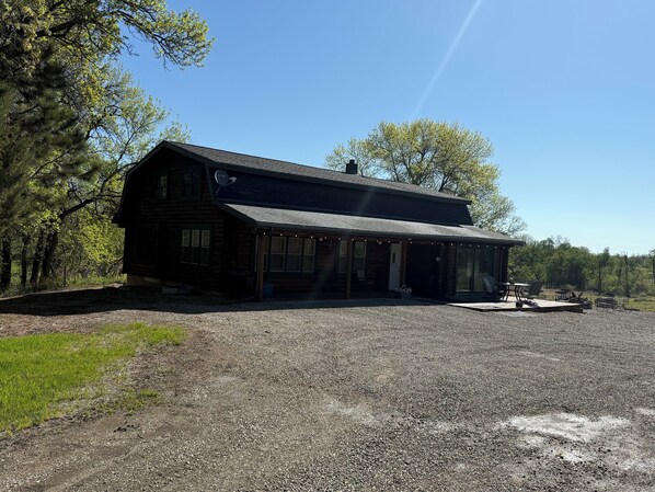 A log cabin with a porch and outdoor seating area. - Cedar Lodge at Turtle Mountain (Dunseith)
