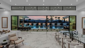 Un intérieur moderne avec une piscine, un espace salon extérieur et une vue sur les montagnes.