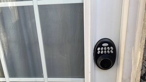 En dörr med ett kodlås och ett handtag av metall.
