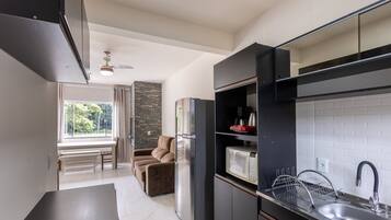 A modern kitchen with a built-in microwave, stainless steel sink, and a refrigerator.