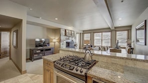 A modern kitchen with a gas stove, a built-in oven, and a stone fireplace. - 7 Condos, Ski-in/ski-out + Hot Tubs Sleeps 30 Mont Cervin by Avantstay (Park City)
