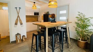 A modern kitchen with wooden countertops, black bar stools, and pendant lighting.