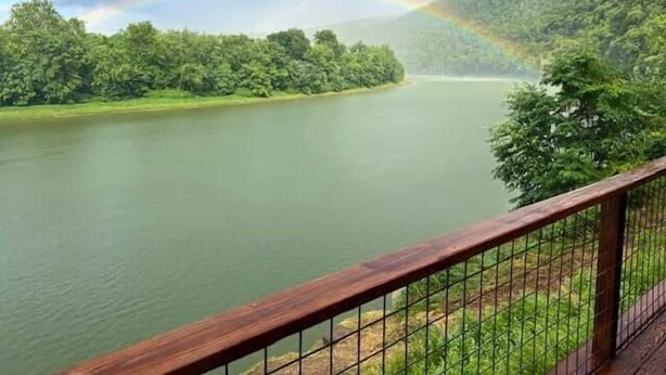 A river with a rainbow, surrounded by lush greenery and hills. - The Moose Lodge on the Susquehanna River (Sugar Run)