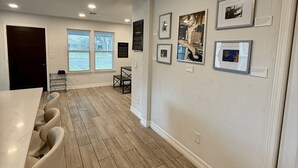 A modern interior with a dining area, wooden flooring, and wall-mounted artwork. - 3rd Ward Gem: Modern Comfort + History (Houston)