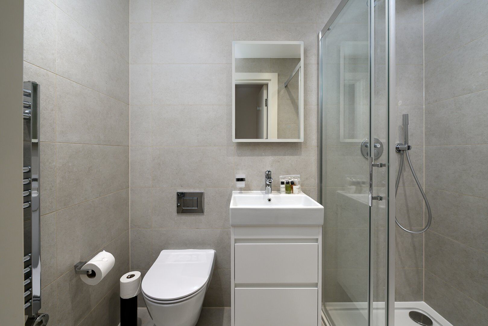 A modern bathroom with a toilet, sink, and shower.