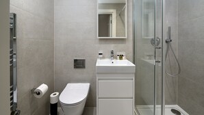 Un bagno moderno con servizi igienici, lavandino e doccia.