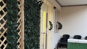 A room with a wooden lattice wall covered in green foliage, a white partition, and a small seating area with black chairs. - Poetto di Cagliari vacation home 2 steps from the sea, relax sport and fun (Cagliari)