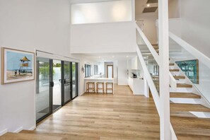Un interior moderno con cocina, comedor y escalera.