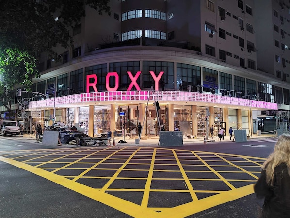 Een gebouw met een opvallend 'ROXY'-bord, uitgevoerd in moderne architectuur met grote ramen en een gebogen gevel.