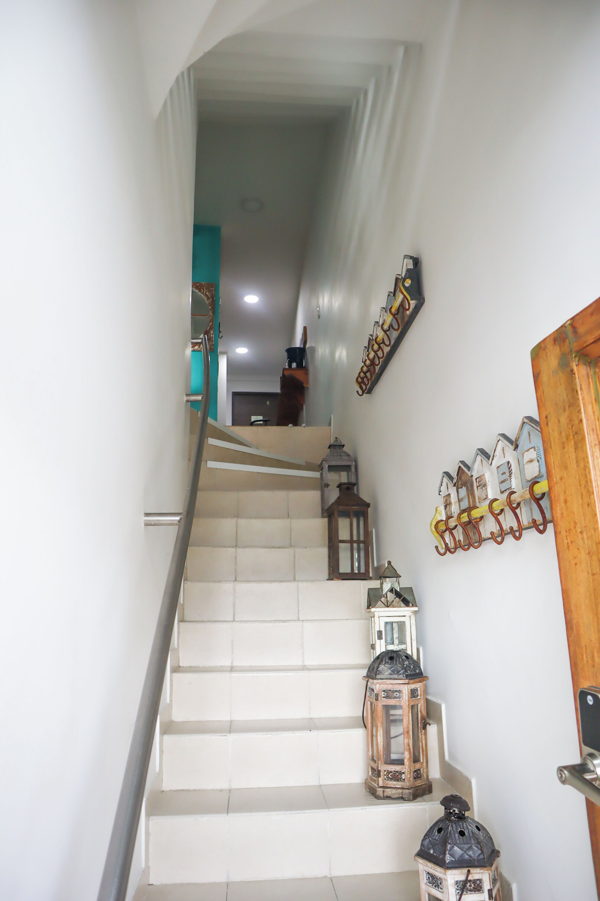 A staircase with white steps, a wooden door, and decorative lanterns.