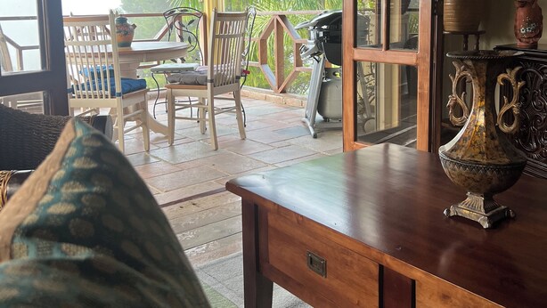 A cozy room with a wooden table, a decorative vase, and a view of the outdoors. - Summit LuxeVilla (Constanza)