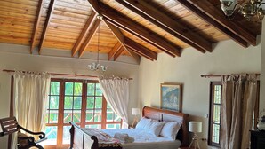 A wooden-floored bedroom with a bed, rocking chairs, and a chandelier. - Summit LuxeVilla (Constanza)