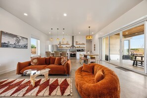 A modern living room with a sofa, a coffee table, and a rug. - Desert Spa: Heated Pool · Hot Tub · Sauna · Cold Plunge · New Home - Joshua Tree (Joshua Tree)