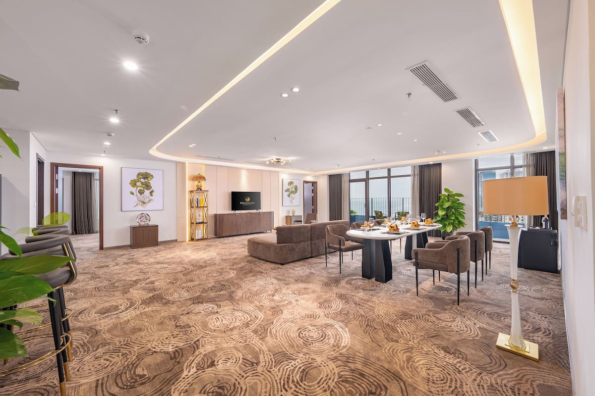Een moderne hotelkamer met een zithoek, eethoek en een groot raam met uitzicht.