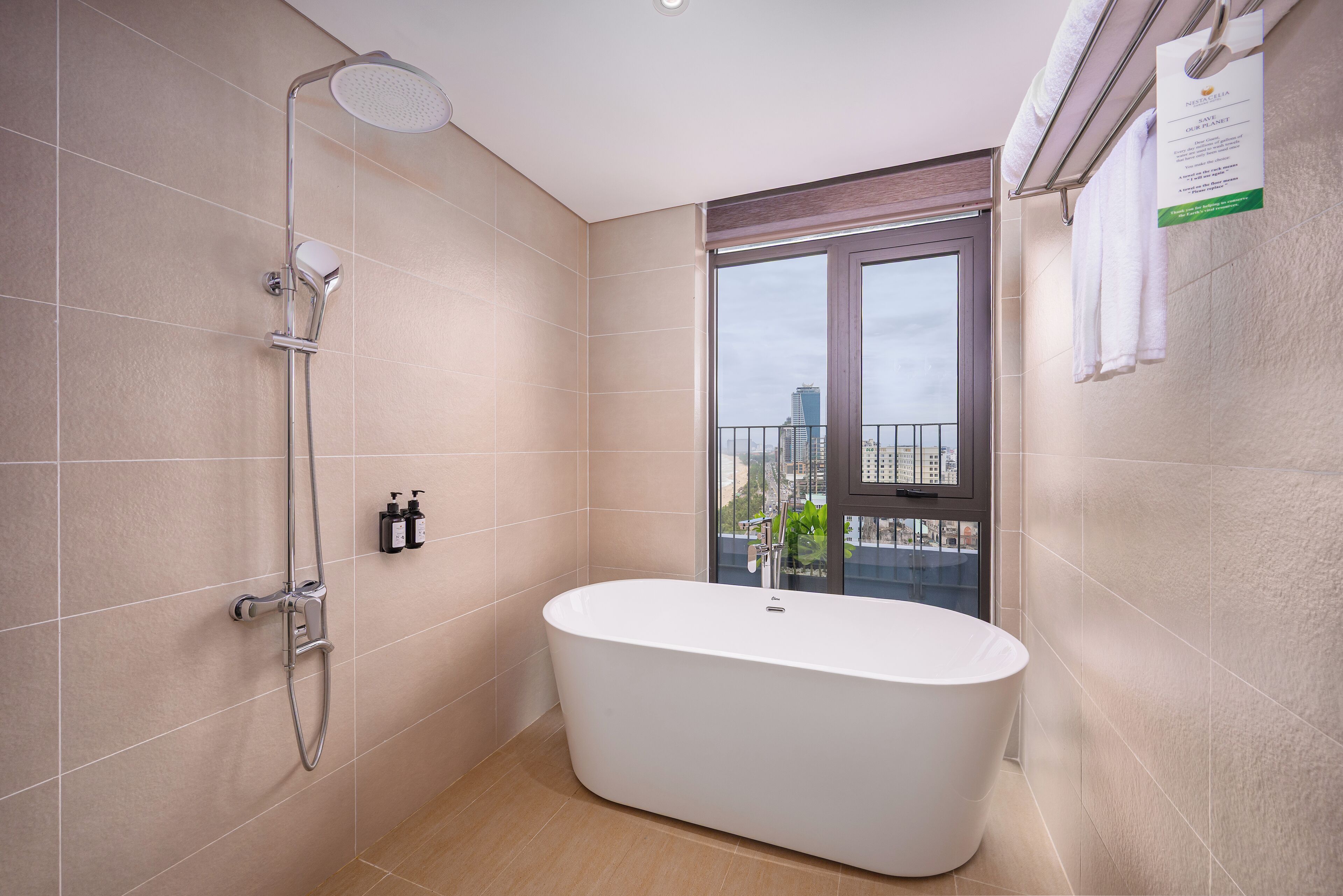 A modern bathroom with a freestanding bathtub, a showerhead, and a window offering a city view.