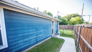 A blue house with a small front yard and a wooden fence. - Cozy Studio Min to JPS, Medical City, Historic District, Zoo, Water Gardens (Fort Worth)