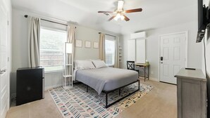 A bedroom with a bed, a ceiling fan, a desk, and a wardrobe. - Cozy Studio Min to JPS, Medical City, Historic District, Zoo, Water Gardens (Fort Worth)