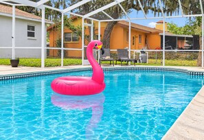 A swimming pool with a pink flamingo float.