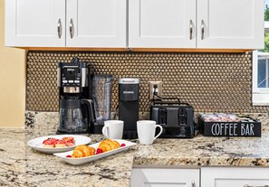 Una cocina con cafetera, tostadora y un letrero que dice 'Coffee Bar'.