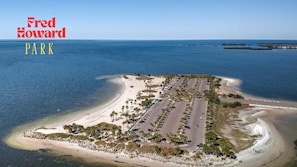 An aerial view of Fred Howard Park with a beach, parking area, and clear blue water.