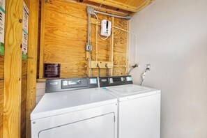 Un espace dédié à la buanderie, avec un lave-linge blanc et un panneau de commande.