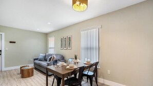 A dining area with a wooden table, black chairs, and a grey sofa.