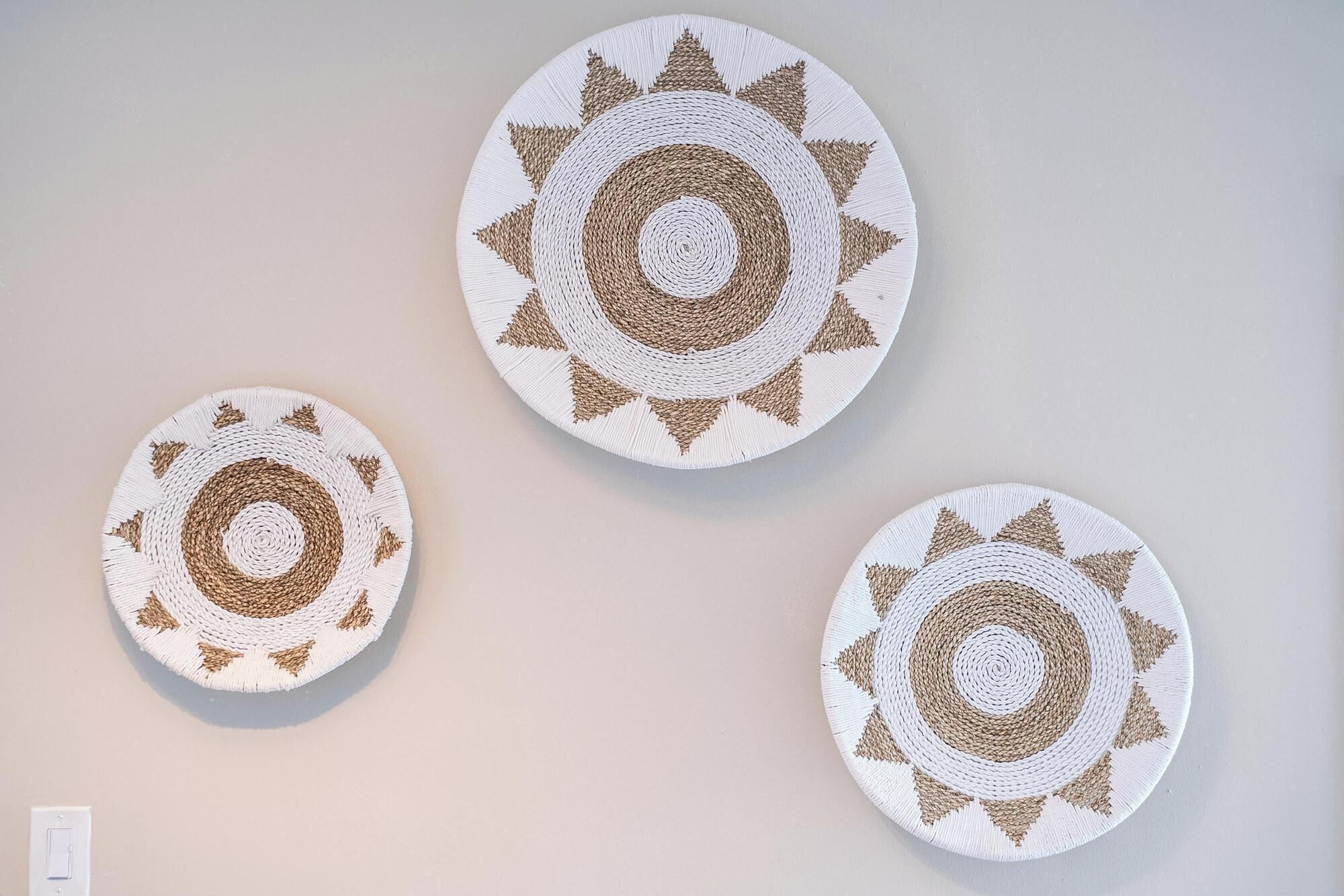 Three circular woven wall hangings with concentric circles and triangular patterns.