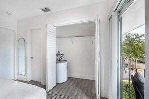 Quarto de hotel moderno com uma cama grande, um closet espaçoso e vista para o exterior.