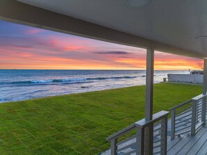 A balcony with a view of the ocean at sunset. - Beach Front Home - Pearl of Oahu's West Side! (Ewa Beach)