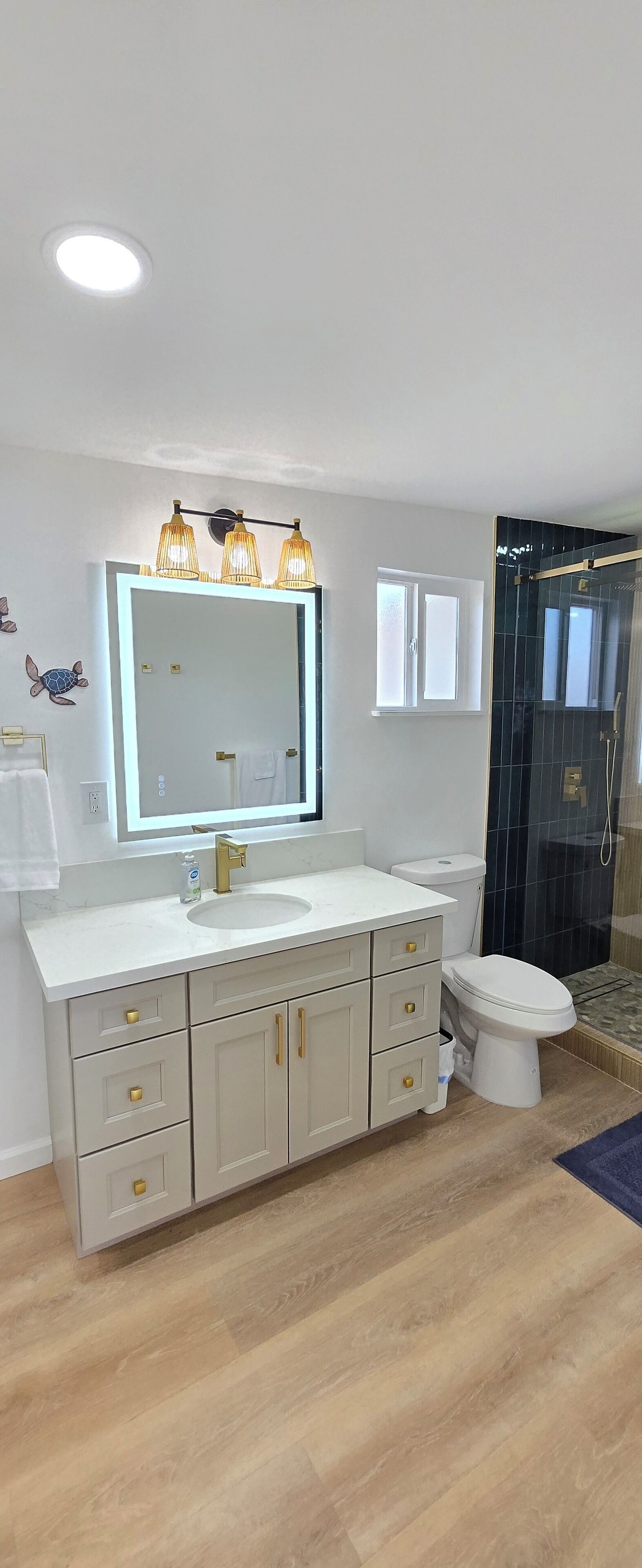 A modern bathroom with a large vanity, a toilet, and a shower area.