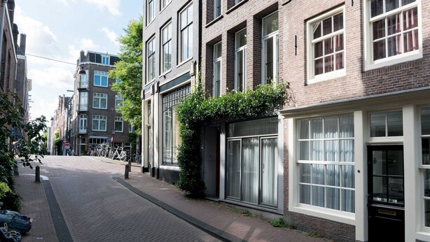 A street with traditional European architecture, featuring brick buildings with large windows and a cobblestone street. - Laurier Apartment - in the Jordaan (Amsterdam)