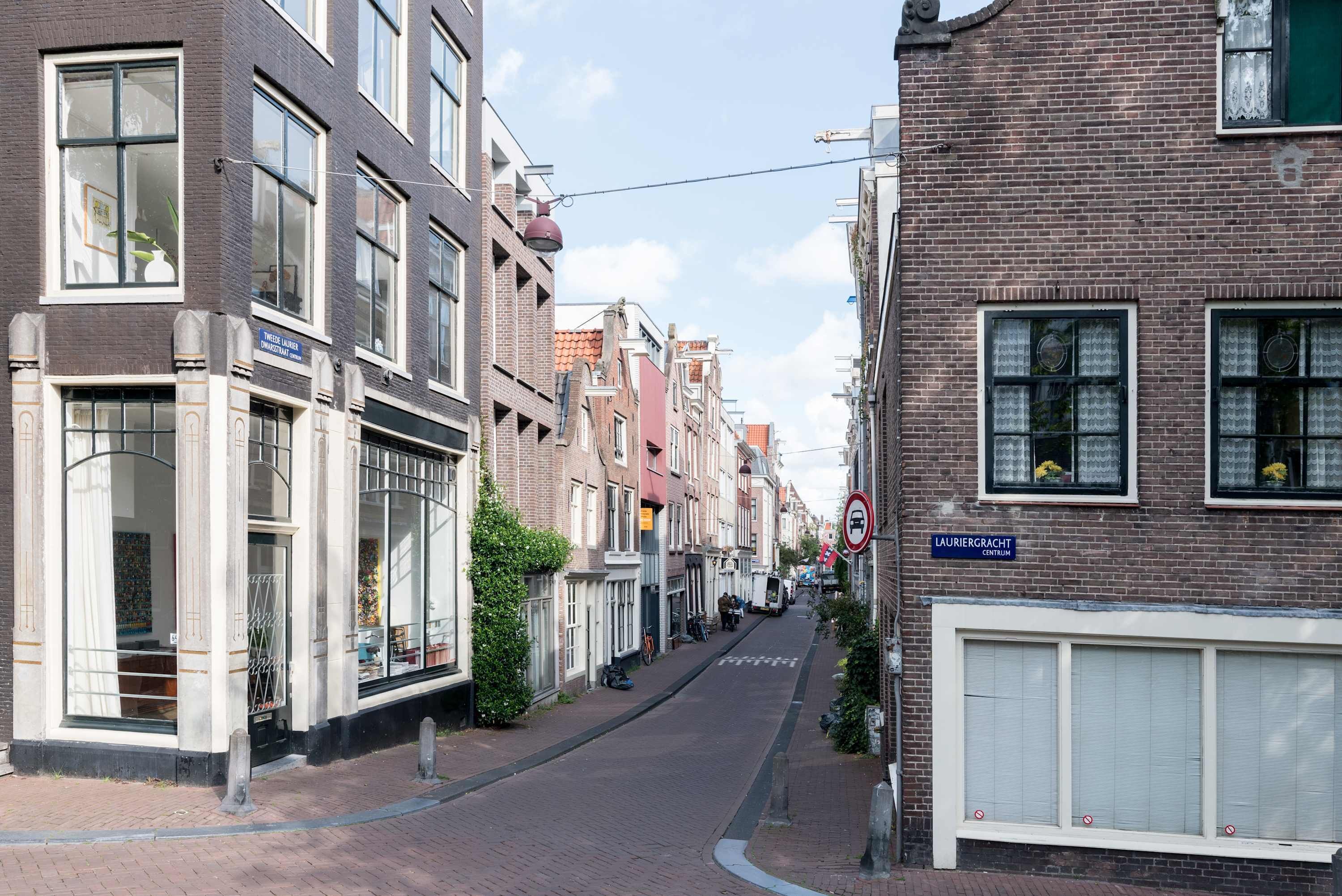 A narrow street lined with traditional European buildings, some with visible signage.