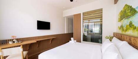 Habitación de hotel moderna con una cama grande, un escritorio de madera, un televisor de pantalla plana y vistas a la ciudad a través de la ventana.