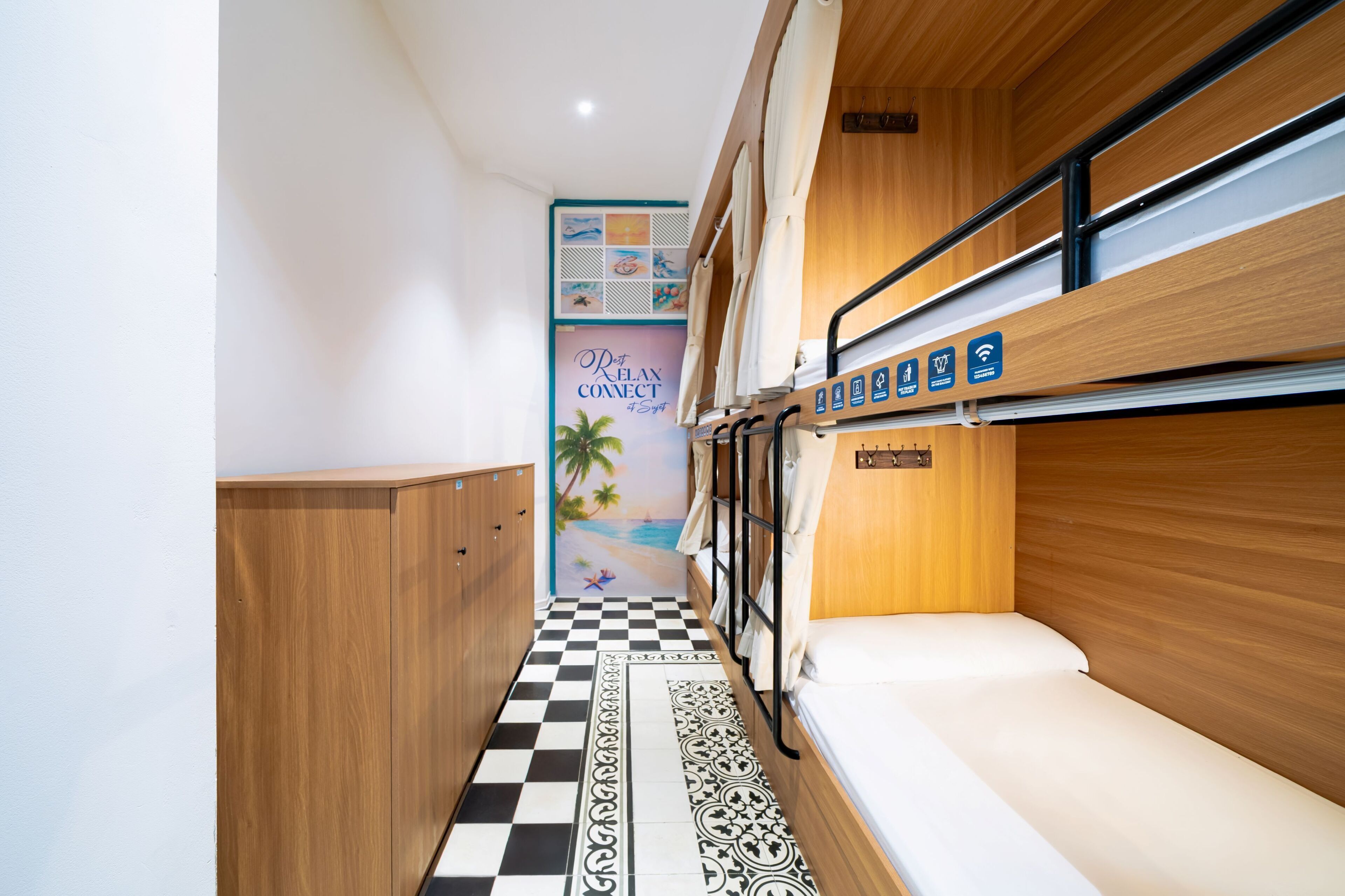 A narrow corridor with a checkered floor, wooden walls, and a bunk bed with a sign indicating amenities.
