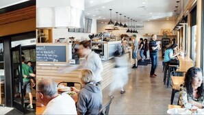 Een modern interieur met een centraal gelegen bakkerijbalie, zitgedeeltes en een duidelijke ingang.