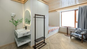 A modern bathroom with a marble sink, a towel rack, and a window with a view.