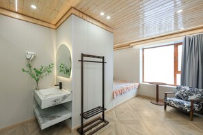 A modern bathroom with a marble sink, a towel rack, and a window with a view.