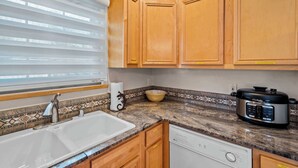 A kitchen with wooden cabinets, a sink, a dishwasher, and a crockpot. - Walk to Plaza and Railyard, Fire Pit (Santa Fe)