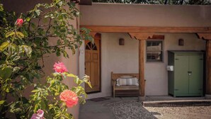 A building with a wooden door, a bed, and a green cabinet. - Walk to Plaza and Railyard, Fire Pit (Santa Fe)
