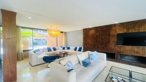 Una sala moderna con un sofá seccional, una mesa de centro y un mueble para televisión.