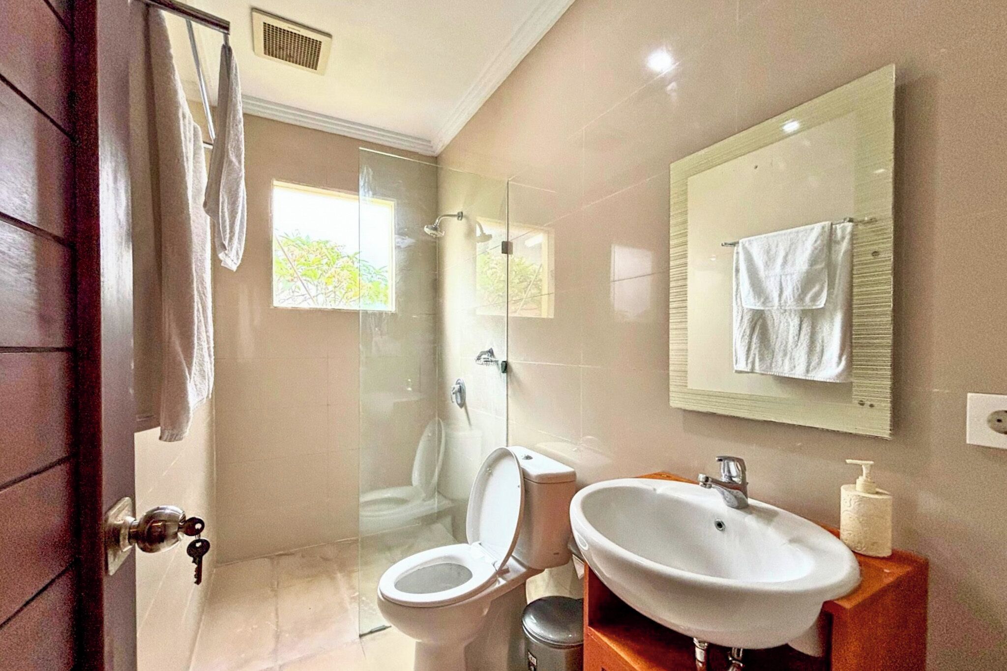 A bathroom with a toilet, sink, and shower.