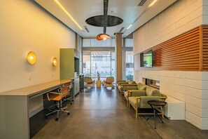 A modern interior with a reception desk, seating area, and a large window with a view. - Explore Downtown Phoenix, AZ | Pool, Gym & Parking (Phoenix)