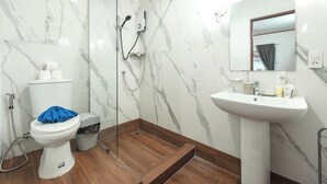 Een badkamer met toilet, douche en wastafel.