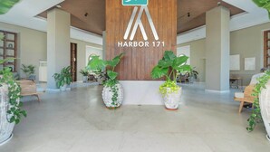 A spacious lobby with a wooden ceiling, large potted plants, and a prominent BP sign.