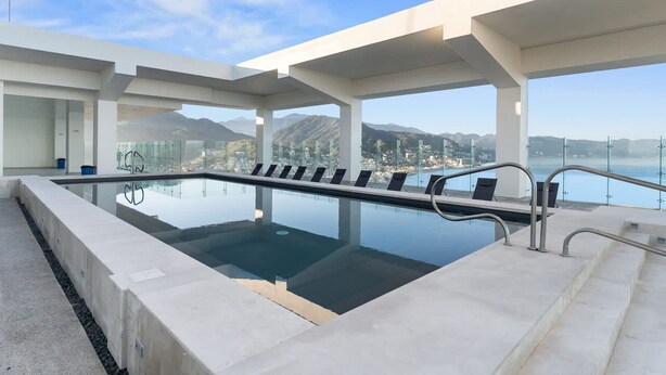 An infinity pool with a clear view of a mountainous landscape.