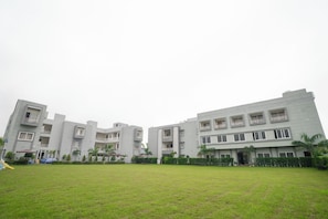A modern building with multiple balconies and a flat roof. - Savanna Retreat by Nuva Stayz (Ramnagar)