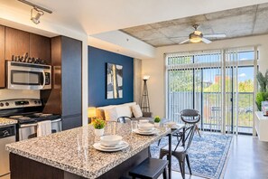 A modern kitchen with granite countertops, a built-in microwave, and a stove.