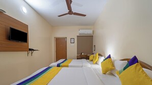 A hotel room with two beds, a television, a ceiling fan, and an air conditioning unit. - Itsy Hotels Everest Leela Residency (Erode)